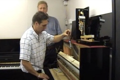 Paul is carrying out a piano tuning near me while James looks on in the background, showing piano tuning cost and how much does it cost to tune a piano, with clear guidance on how much does piano tuning cost in the UK